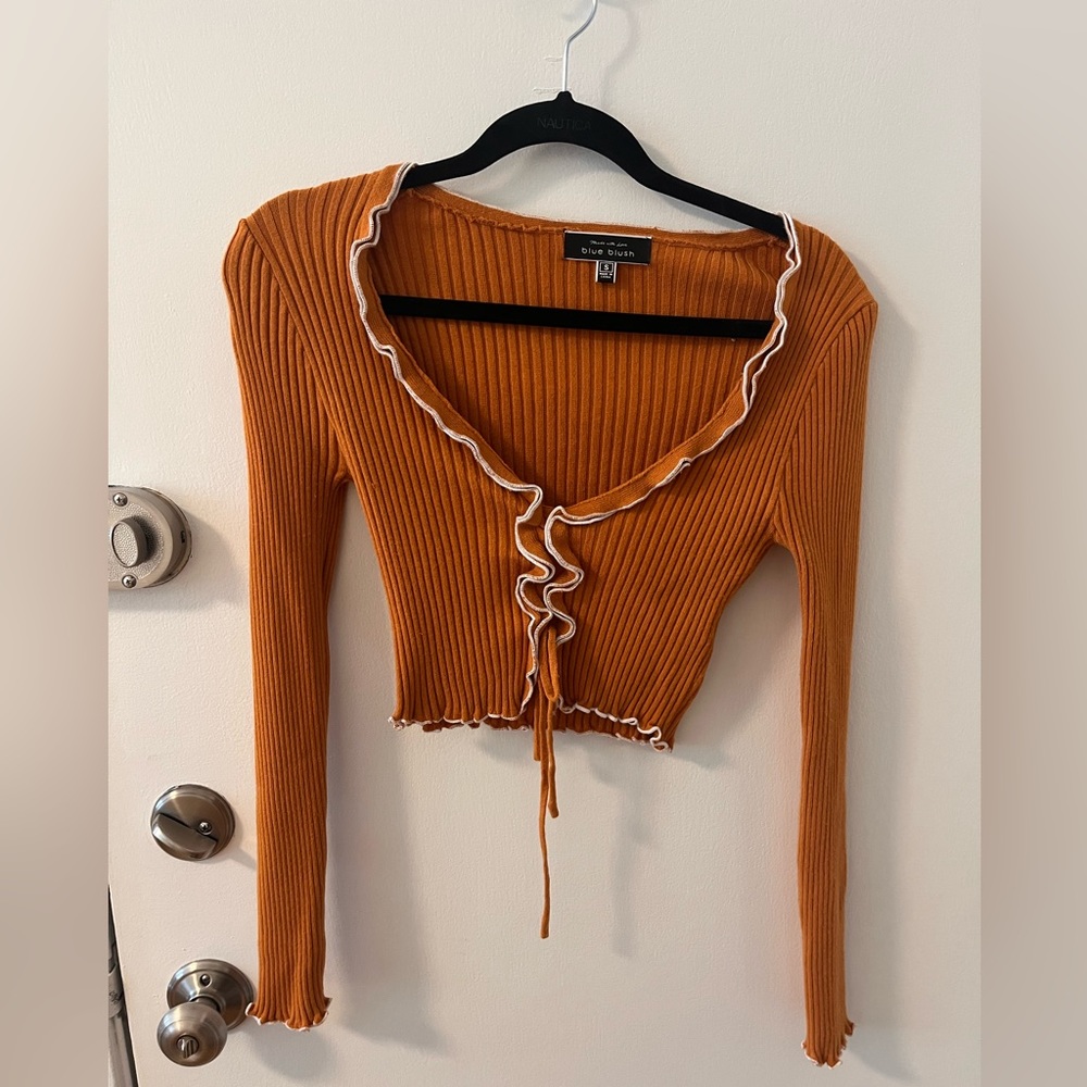 Orange cropped kit sweater with white fringe lining